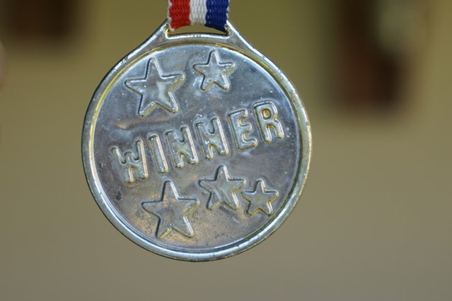 Zilveren medaille met 5 sterren en tekst winnaar 