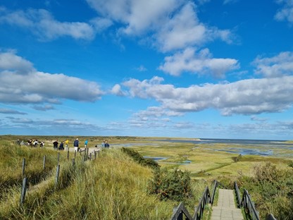 afbeelding van wandelaars op De Slufter met weids uitzicht.