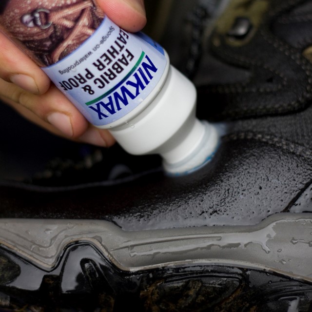 afbeelding van iemand die zijn wandelschoenen wast en waterdicht maakt.
