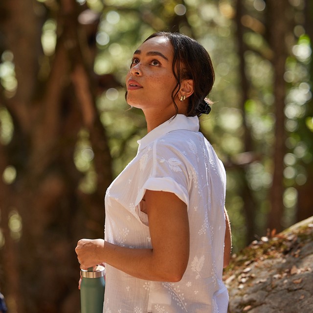vrouw draagt een witte blouse in de natuur, de Oasis Short Sleeve van Royal Robbins.