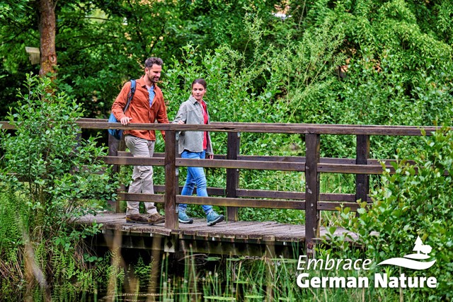 man en vrouw lopen over een houten brug in biosfeerreservaat Midden-Elbe.