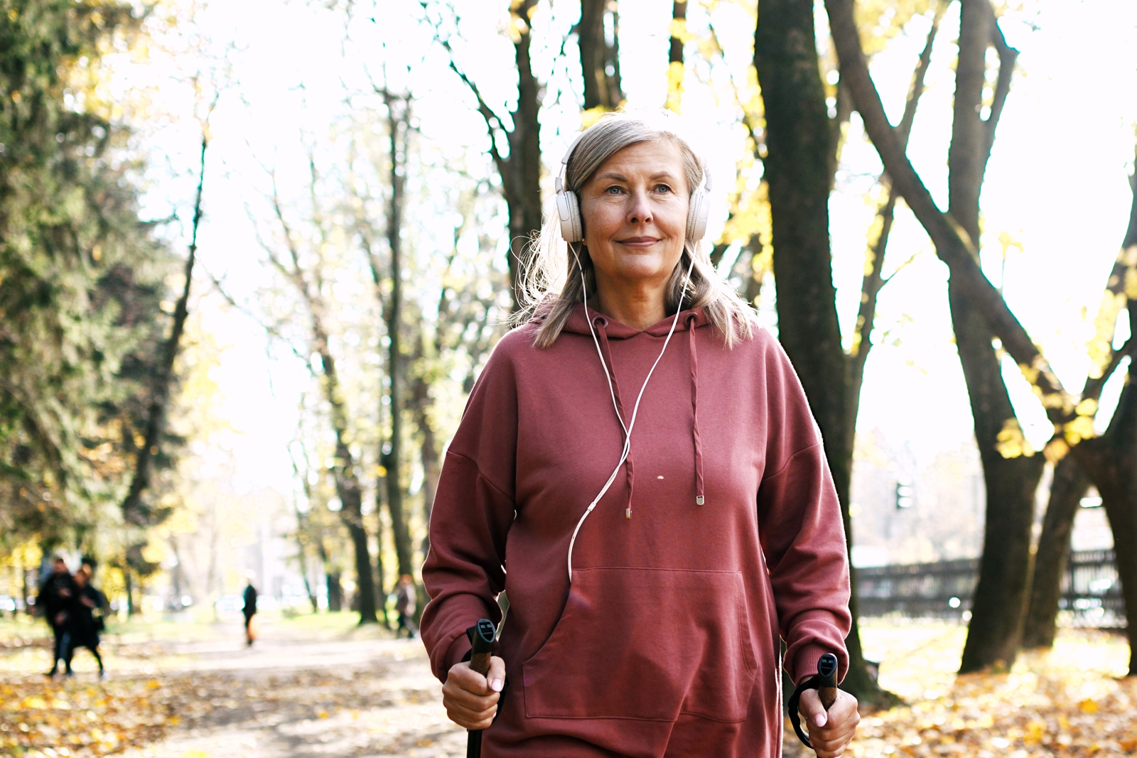 vrouw die met een koptelefoon wandelt in het park
