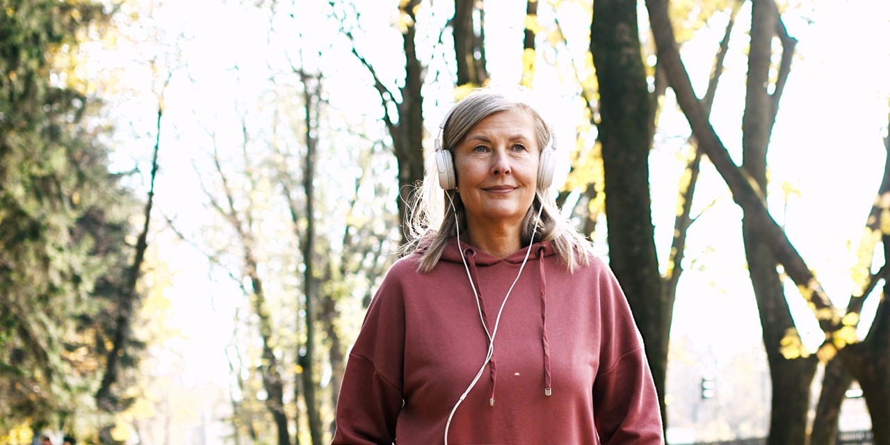 vrouw die met een koptelefoon wandelt in het park