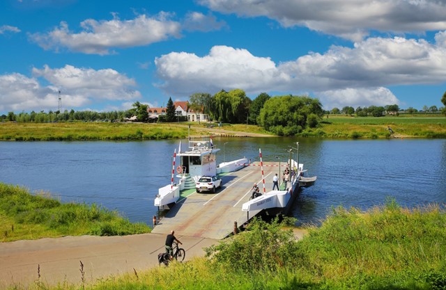 afbeelding van een pontje over de Maas op een zonnige dag.