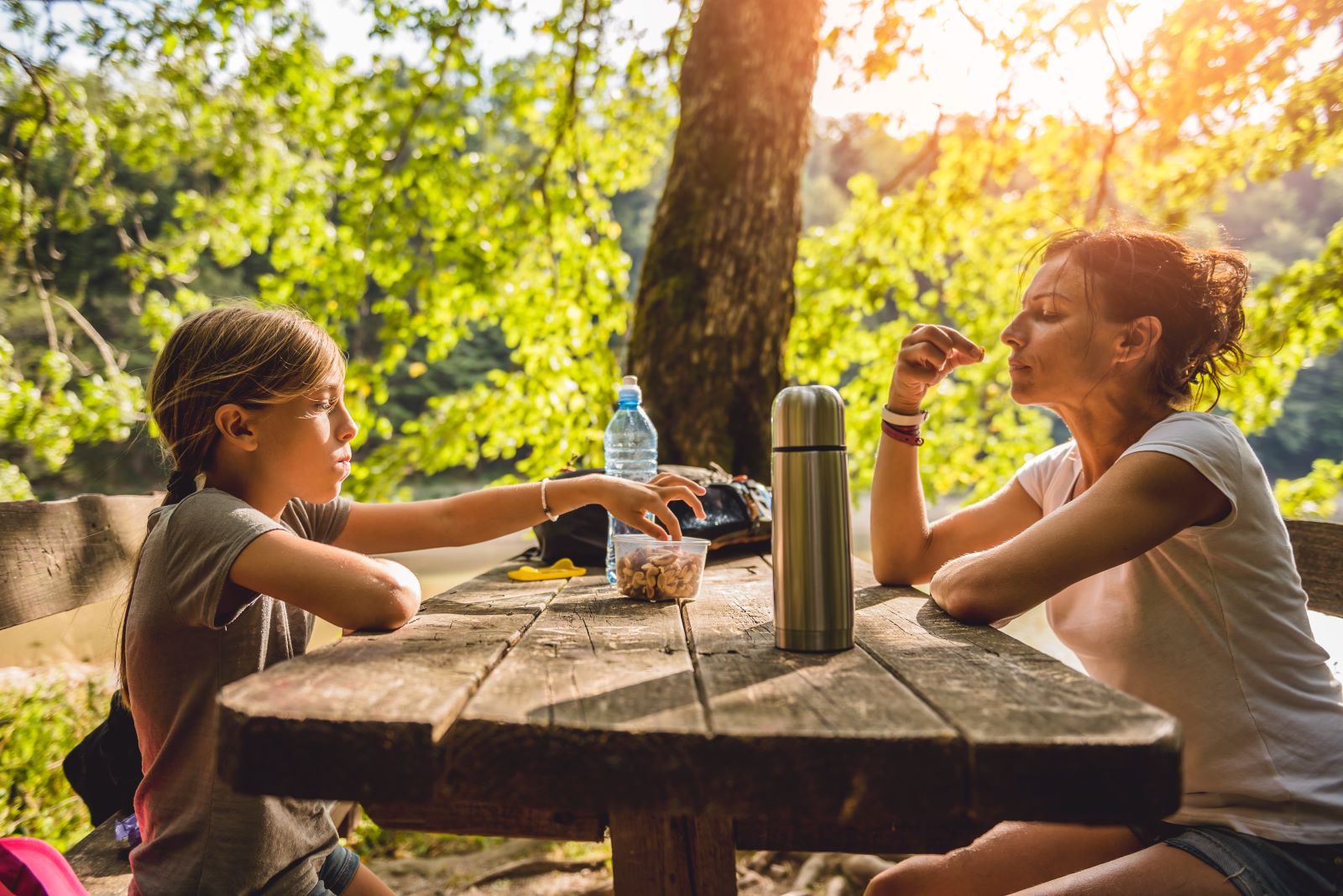 afbeelding van een moeder en dochter die vegan snacken tijdens een wandeling.