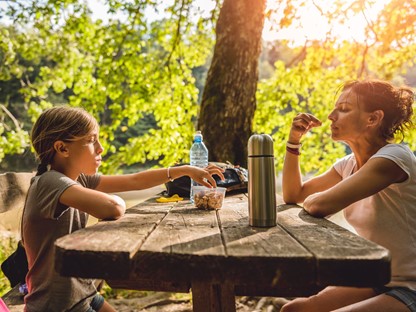 afbeelding van een moeder en dochter die vegan snacken tijdens een wandeling.