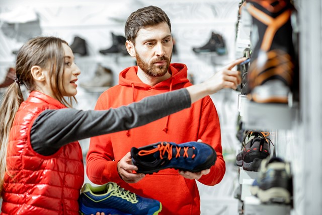 afbeelding van een wandelaar die nieuwe schoenen koopt.