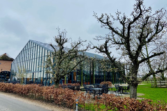 afbeelding van een terras bij een landwinkel, met bloesem.