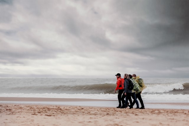 wandelaars op het strand aan zee.