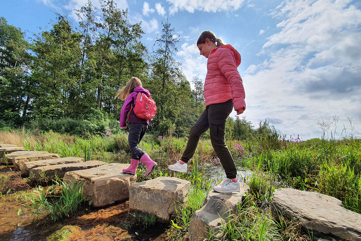kinderen wandelen over stapstenen