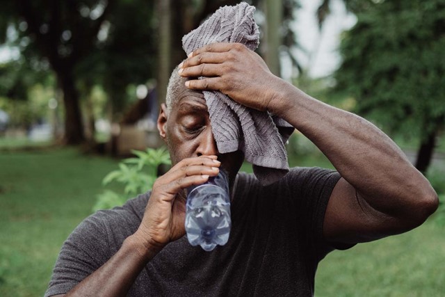 foto van een man die zweet en drinkt.