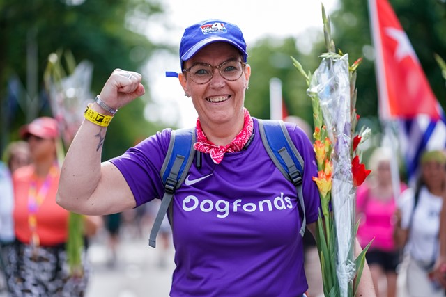 Bianca bij de intocht van de 4Daagse Nijmegen met een Oogfonds-shirt en gladiolen in haar arm.