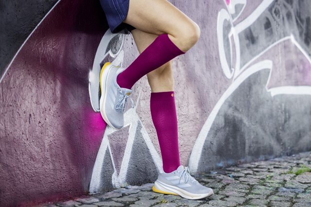 Sporter met paarse compressiesokken