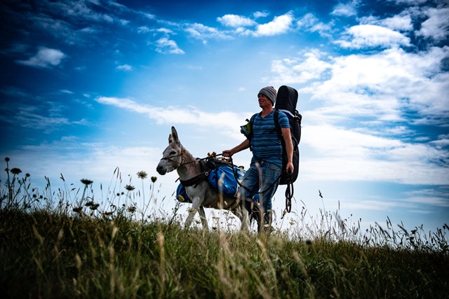 afbeelding van Tjerk Ridder en ezel Lodewijk onderweg, tijdens hun wandelreis.