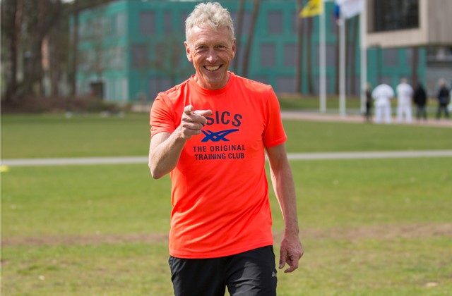 Wandeltrainer kijkt en wijst naar camera