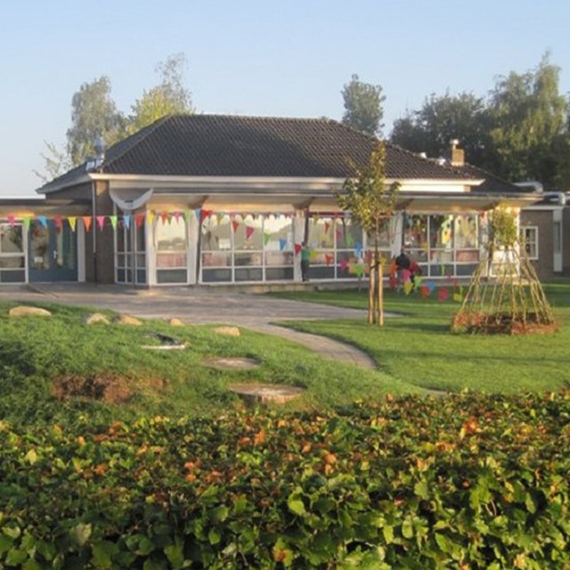 afbeelding van een school met vlaggetjes in het groen.